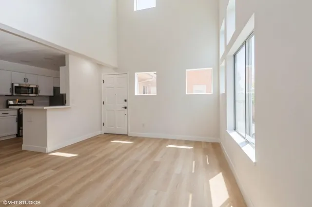 a view of a kitchen with wooden floor and electronic appliances