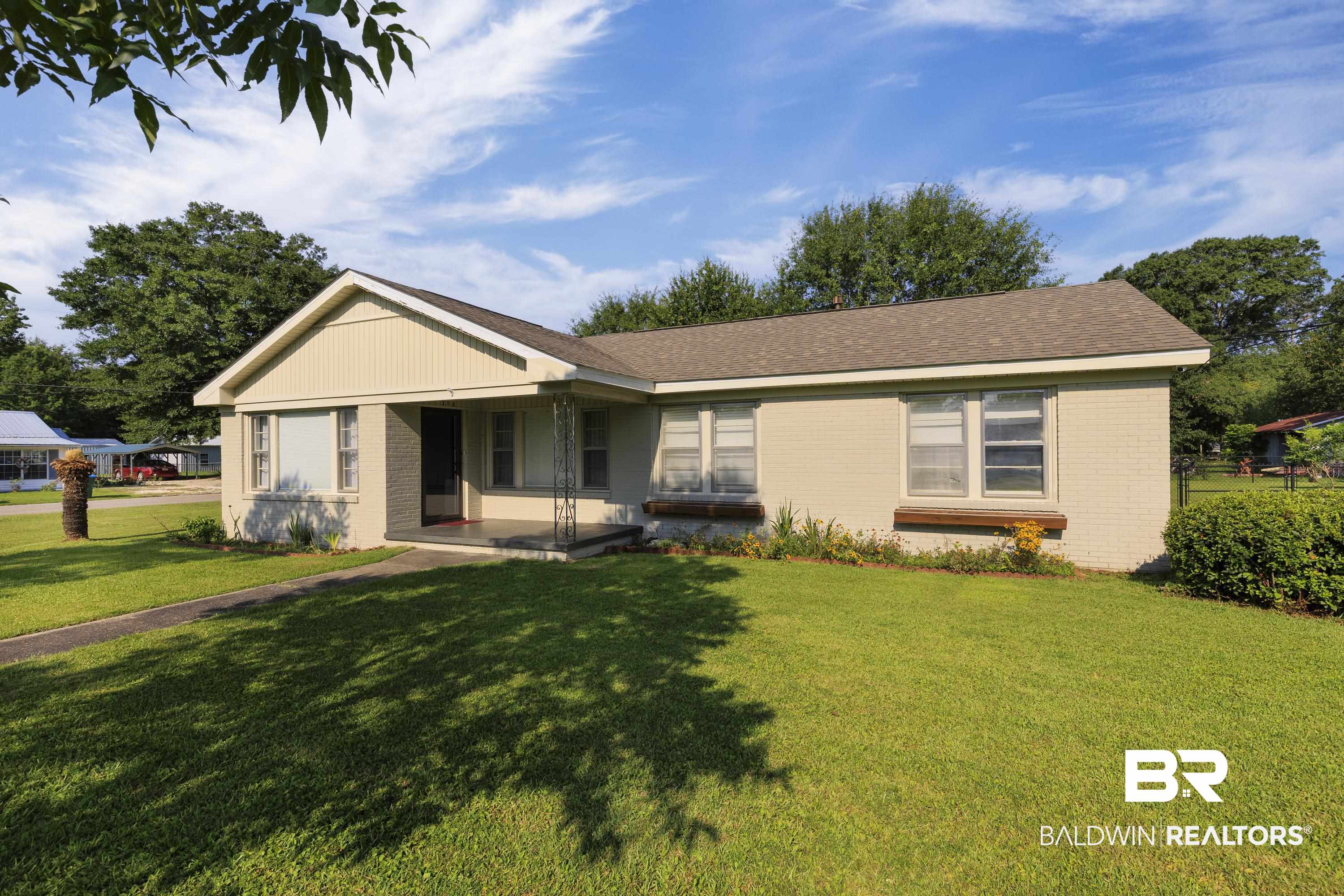 208 Beck Street Atmore, AL 36502 - Photo 1 of 26 Ranch-style home with brick siding, a front yard, a porch, and a shingled roof