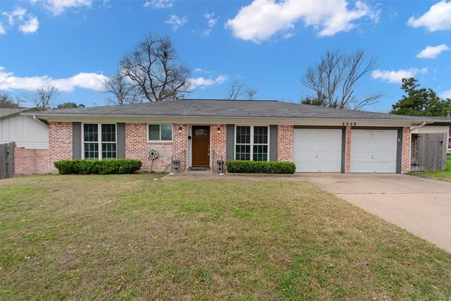a front view of house with yard and trees around