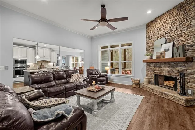 a living room with furniture a rug kitchen view and a window