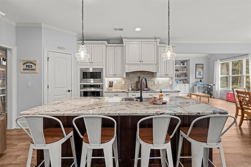 5330 North Helton Road Winston, GA 30187 - Photo 18 of 65 a kitchen with stainless steel appliances granite countertop a table chairs stove and kitchen island