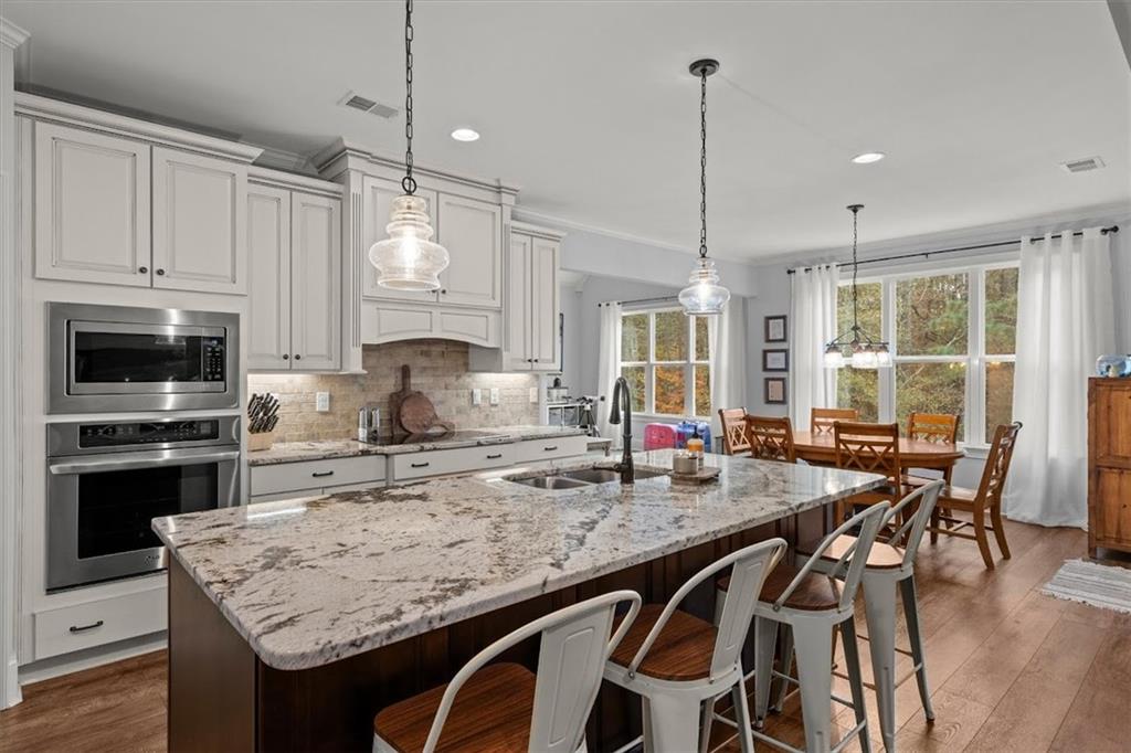 5330 North Helton Road Winston, GA 30187 - Photo 20 of 65 a kitchen with kitchen island granite countertop a table chairs sink and stove