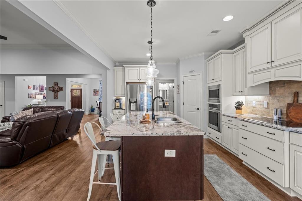 5330 North Helton Road Winston, GA 30187 - Photo 21 of 65 a kitchen with kitchen island granite countertop a sink cabinets and wooden floor