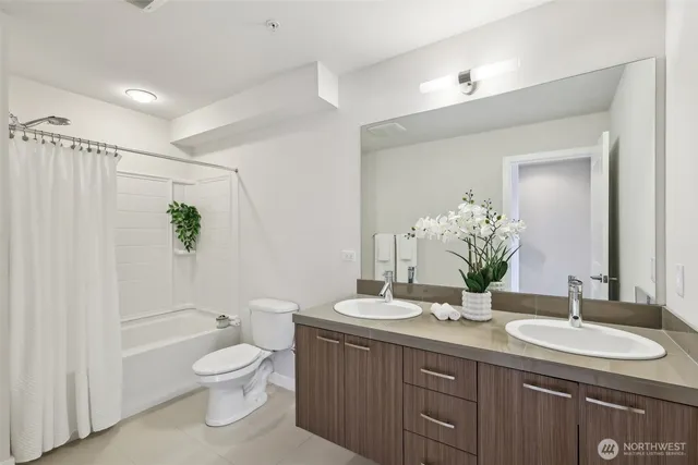 a bathroom with a granite countertop sink a toilet and a large mirror