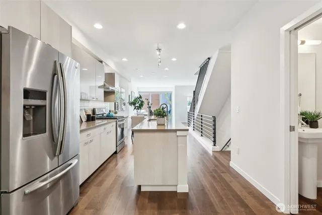 a kitchen with counter top space stainless steel appliances and wooden floor
