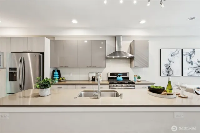 a kitchen with stainless steel appliances granite countertop a sink a stove and a refrigerator