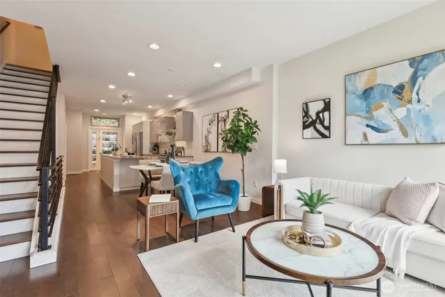 a living room with furniture kitchen view and a potted plant