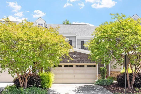 a front view of a house with a yard and a garage