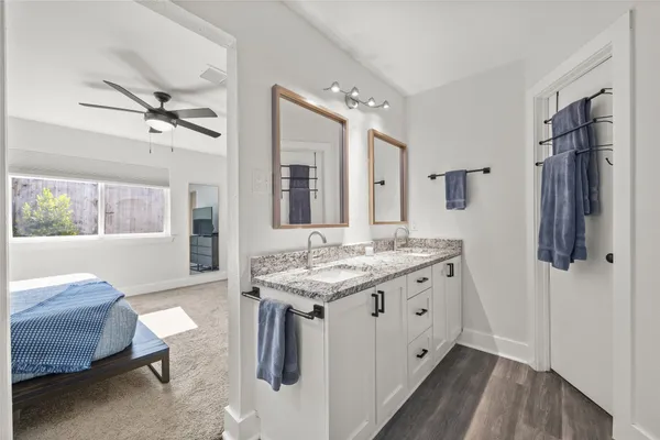 a spacious bathroom with a granite countertop sink a mirror and a shower