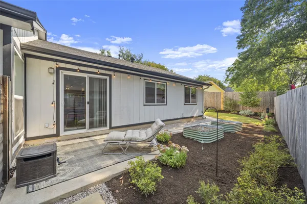 a view of a house with backyard and sitting area