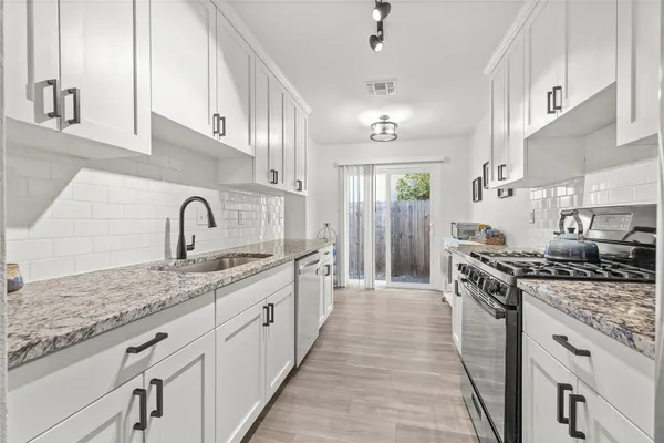a kitchen with stainless steel appliances granite countertop a sink stove and refrigerator