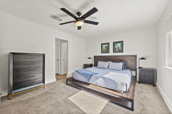a bedroom with a bed and a ceiling fan