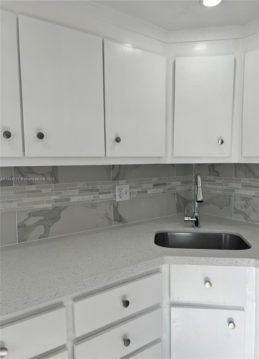 a view of cabinets with stainless steel appliances white cabinets and a sink