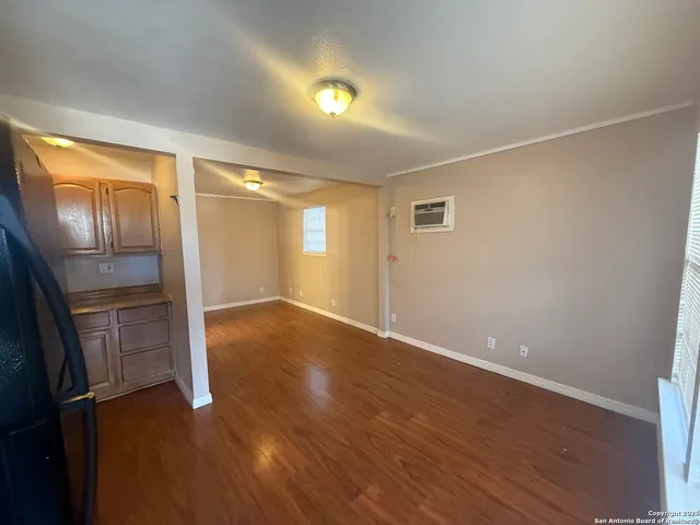a view of empty room with wooden floor