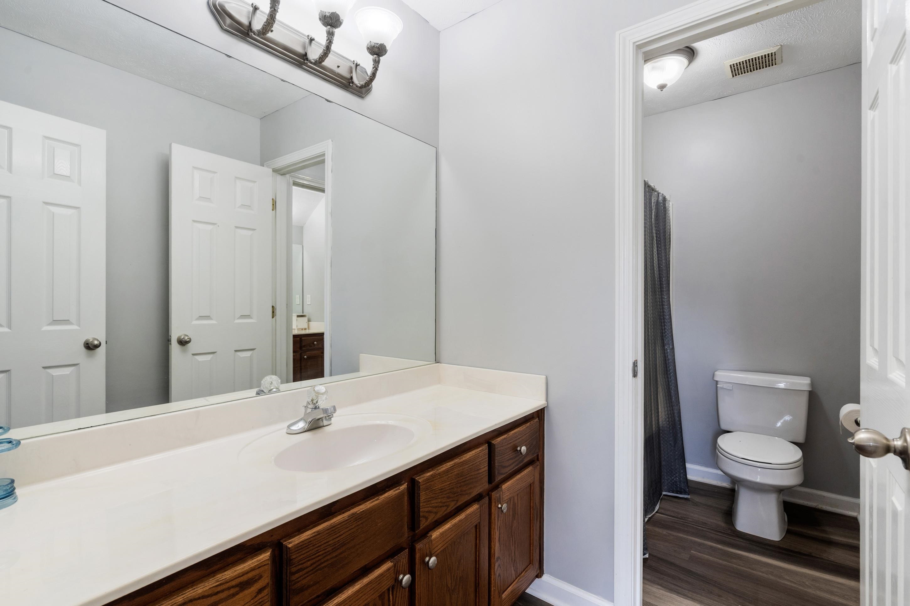 7757 Brunswick Road Millington, TN 38053 - Photo 21 of 40 Bathroom featuring a wood-finish vanity with a light-colored countertop and an integrated sink
