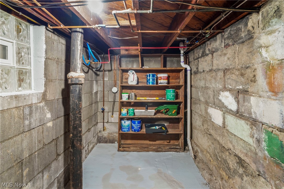 629 Clinton Street Niles, OH 44446 - Photo 38 of 50 Basement storage area featuring concrete block walls, exposed ceiling joists, and a glass block window