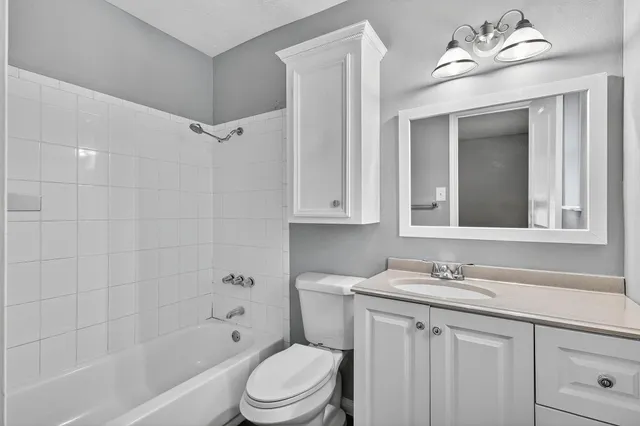 a bathroom with a sink a toilet a mirror and shower