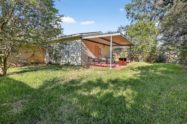 a view of a house with a yard and sitting area