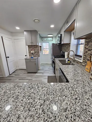 a kitchen with a sink a stove a microwave and cabinets