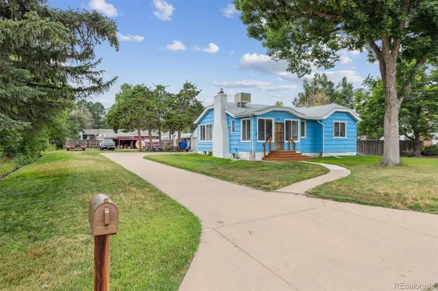 a front view of a house with a yard and trees