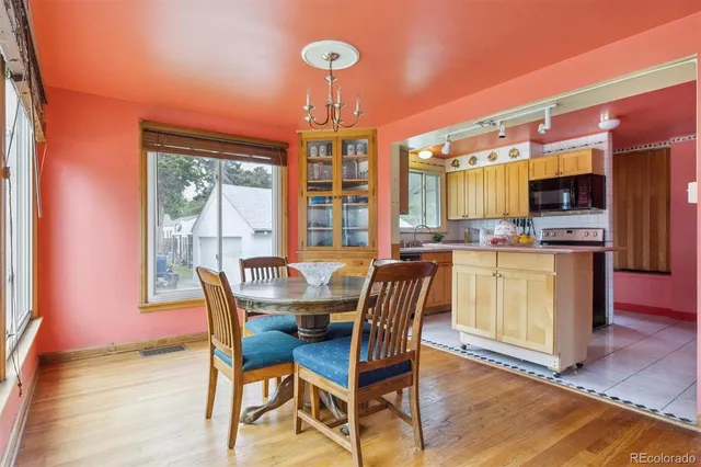 a dining room with furniture a chandelier and wooden floor