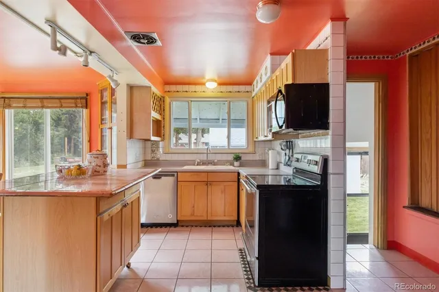 a kitchen with stainless steel appliances granite countertop a sink and a refrigerator