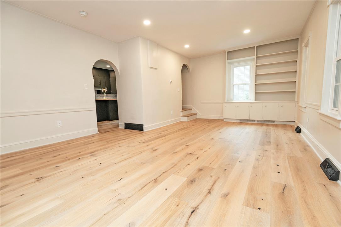 100 Creek Road Bangor, PA 18013 - Photo 37 of 51 Bright hardwood floors flow throughout this living space, highlighting built-in shelving and an arched doorway.