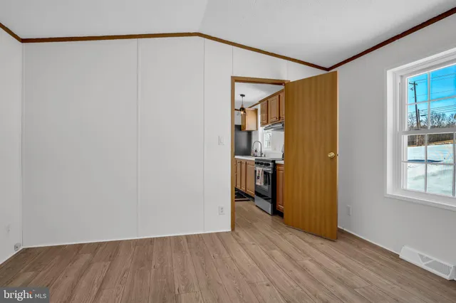 a view of empty room with wooden floor and closet