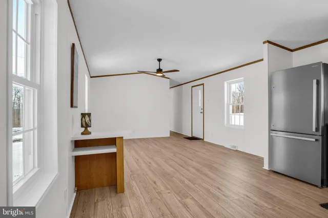 a view of empty room with wooden floor and window