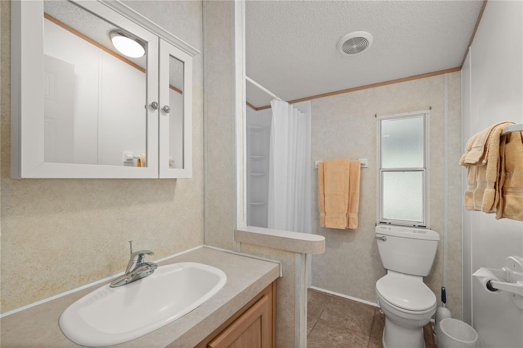 24437 Harbor View Road, Unit 114 Punta Gorda, FL 33980 - Photo 19 of 55 a bathroom with a toilet a sink and mirror