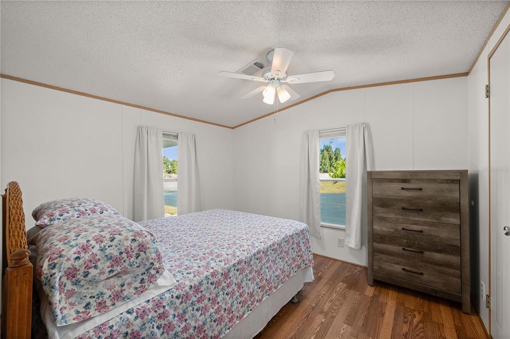 24437 Harbor View Road, Unit 114 Punta Gorda, FL 33980 - Photo 21 of 55 a bedroom with a bed and a dresser