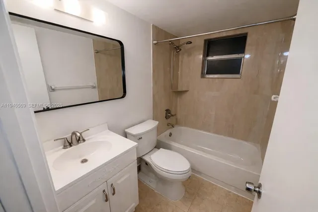 a bathroom with a toilet sink vanity tub and mirror