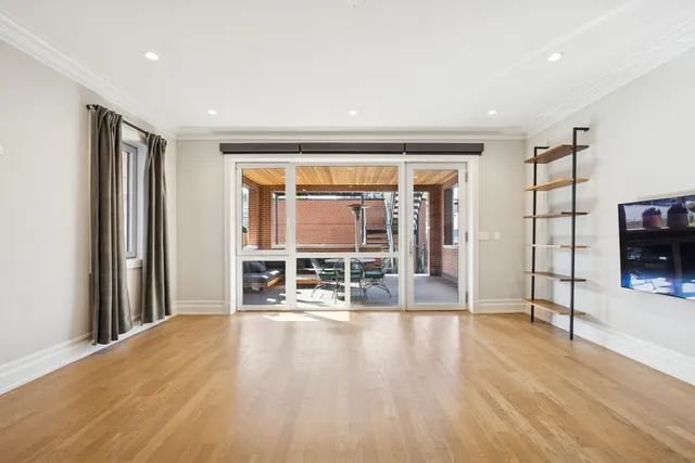 a living room with furniture a flat screen tv and floor to ceiling window