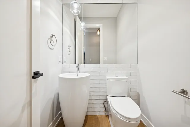 a bathroom with a toilet a sink and mirror