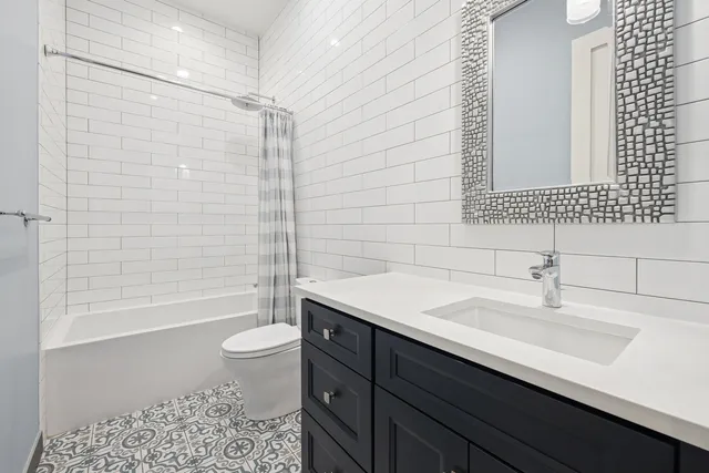 a bathroom with a sink a toilet a mirror and bathtub