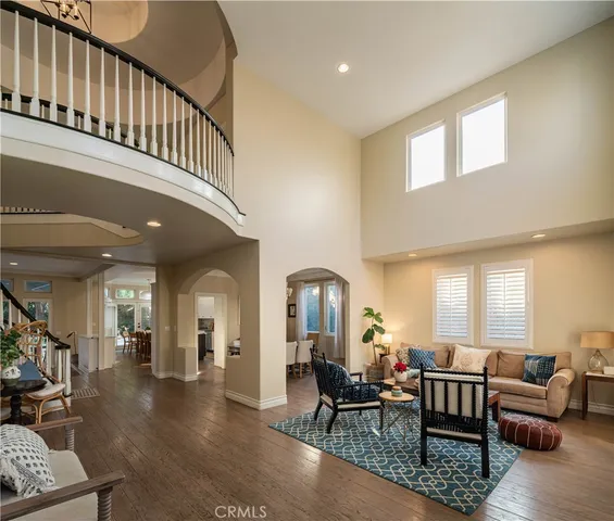 a living room with furniture and a dining table with wooden floor