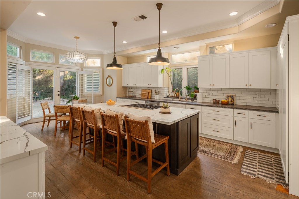 1534 3rd Street Manhattan Beach, CA 90266 - Photo 7 of 21 a kitchen with stainless steel appliances granite countertop a stove a sink a oven a dining table with chairs and white cabinets