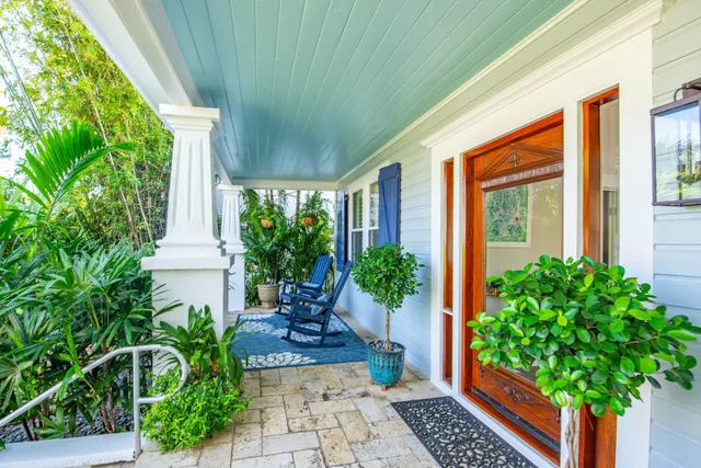 a view of a patio with table and chairs and floor to ceiling window with wooden fence