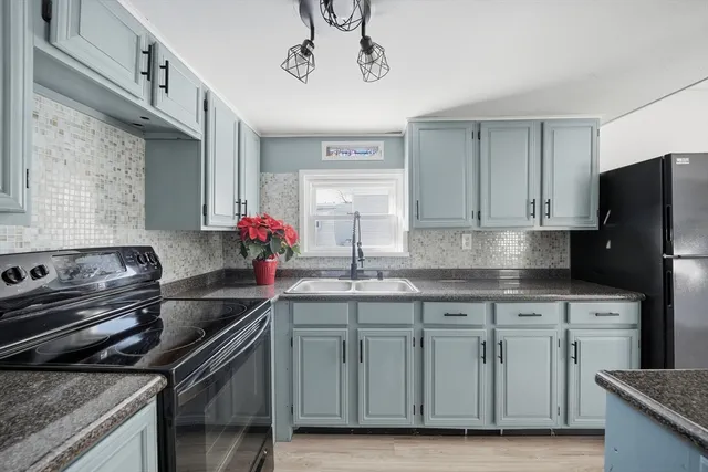 a kitchen with stainless steel appliances granite countertop a refrigerator and a stove top oven