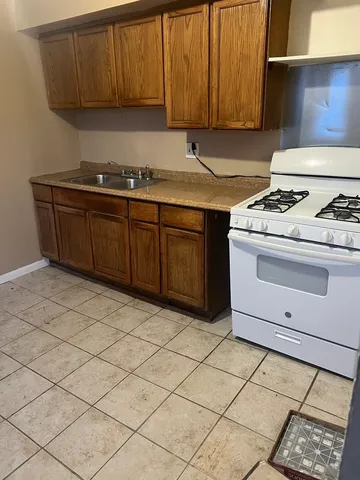 a kitchen with a sink a stove cabinets and utility room