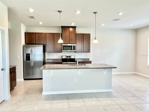 a kitchen with stainless steel appliances a refrigerator a stove a sink and a oven