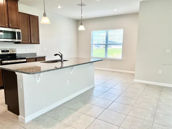 a kitchen with a sink a counter top space cabinets and stainless steel appliances