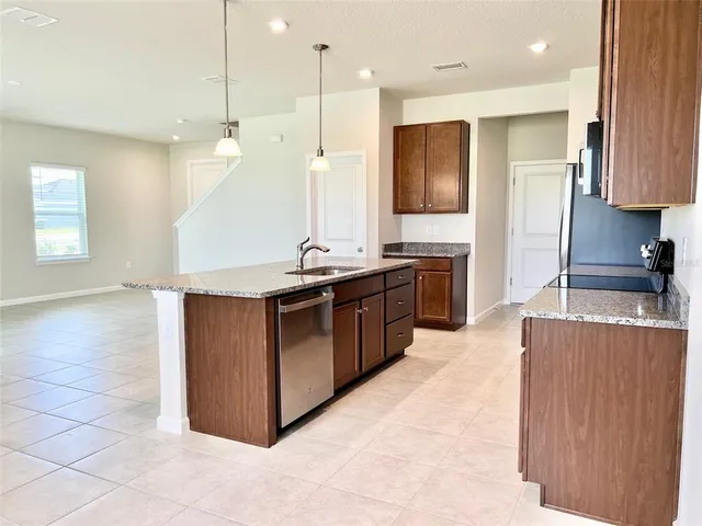 a kitchen with stainless steel appliances granite countertop a stove a sink and a refrigerator