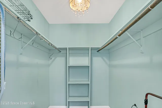 a view of walk in closet with empty racks