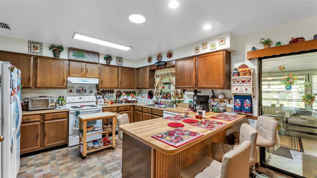1301 Lanier Road Lakeland, FL 33810 - Photo 9 of 45 a open kitchen with stainless steel appliances kitchen island granite countertop a stove top oven a sink dishwasher and cabinets with wooden floor