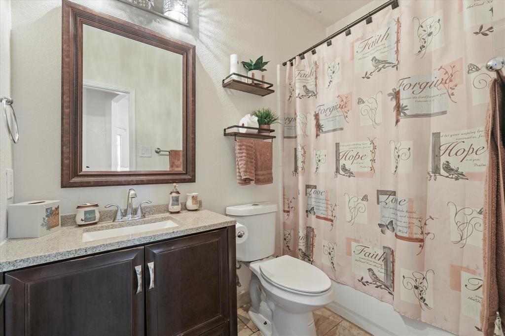 1973 Garrison Way Garland, TX 75040 - Photo 8 of 29 a bathroom with a granite countertop toilet sink and mirror