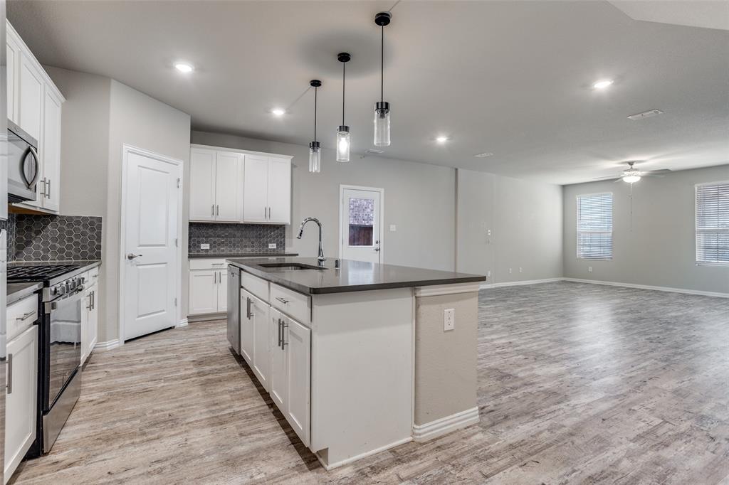 3808 Barnett Road Rowlett, TX 75089 - Photo 5 of 13 a large kitchen with granite countertop a large counter top a sink stainless steel appliances and cabinets