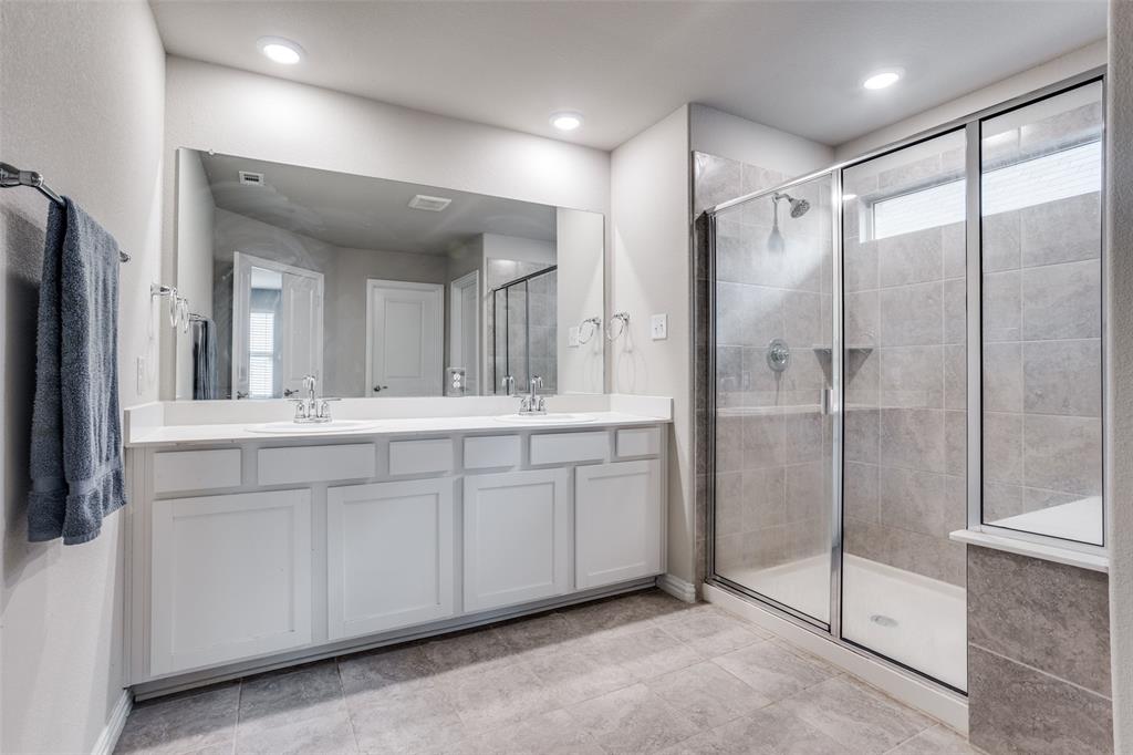 3808 Barnett Road Rowlett, TX 75089 - Photo 9 of 13 a spacious bathroom with a shower a sink and a mirror