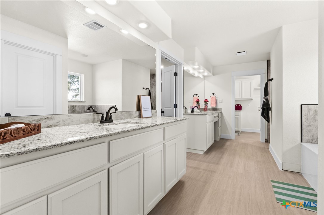 3025 Millhouse Road Copperas Cove, TX 76522 - Photo 17 of 43 a bathroom with a sink double vanity granite tub shower and a mirror