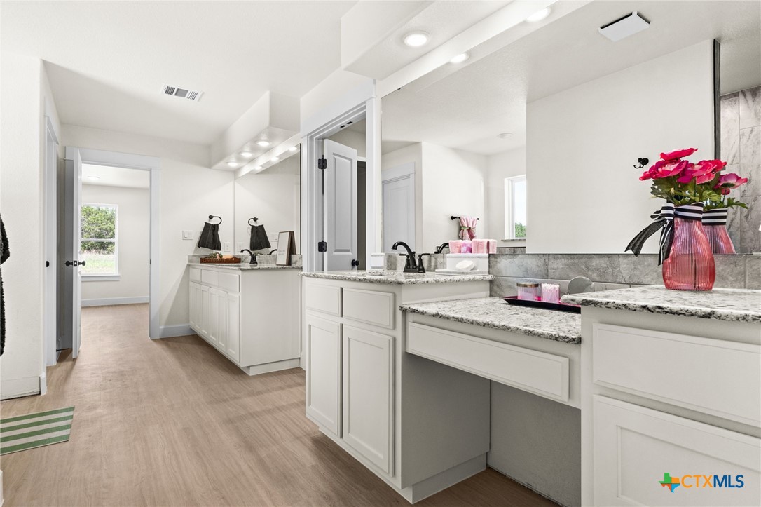3025 Millhouse Road Copperas Cove, TX 76522 - Photo 19 of 43 a kitchen with a sink dishwasher and white cabinets with wooden floor